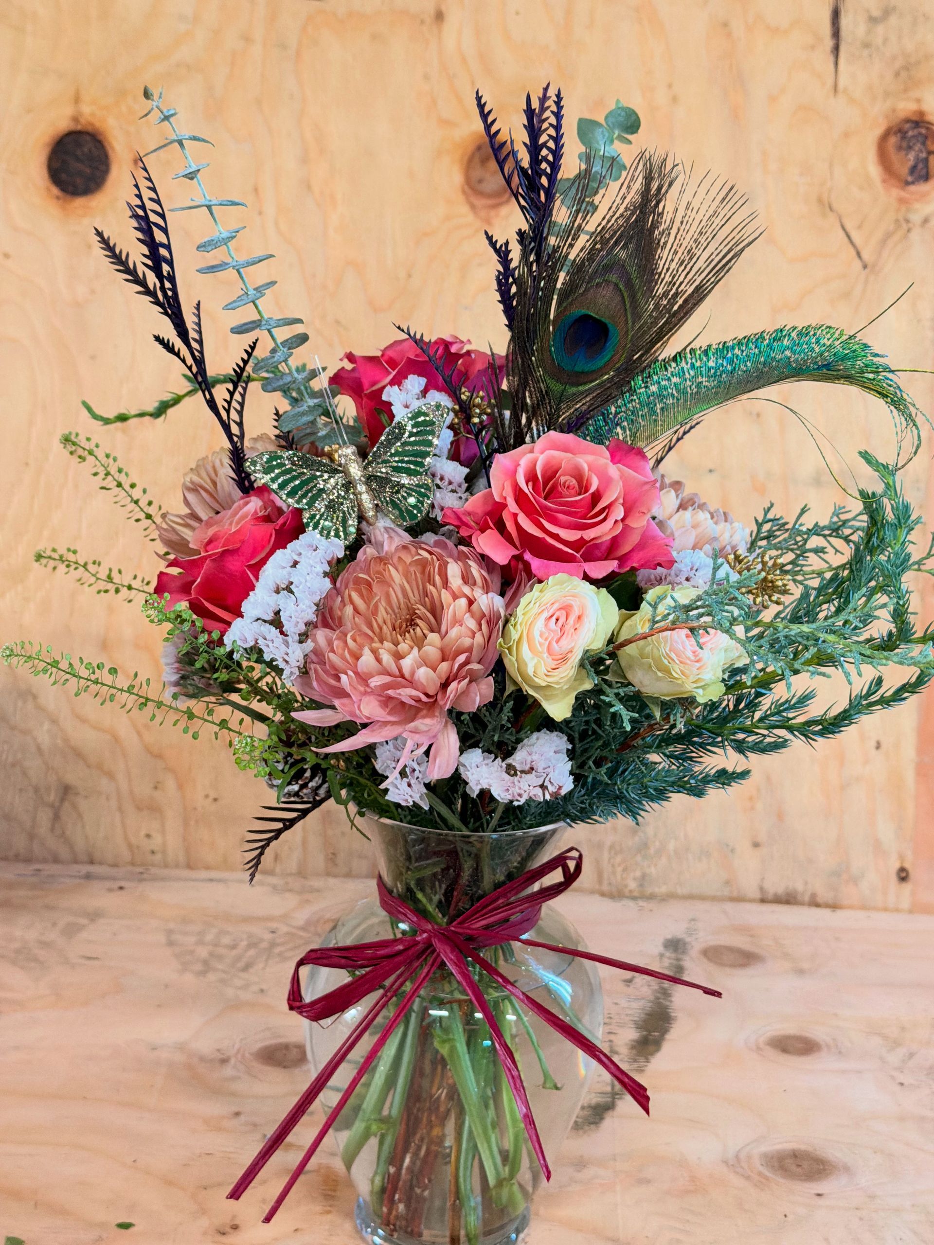 Happy birthday card in a bouquet of pink and peach flowers with pink ribbon.