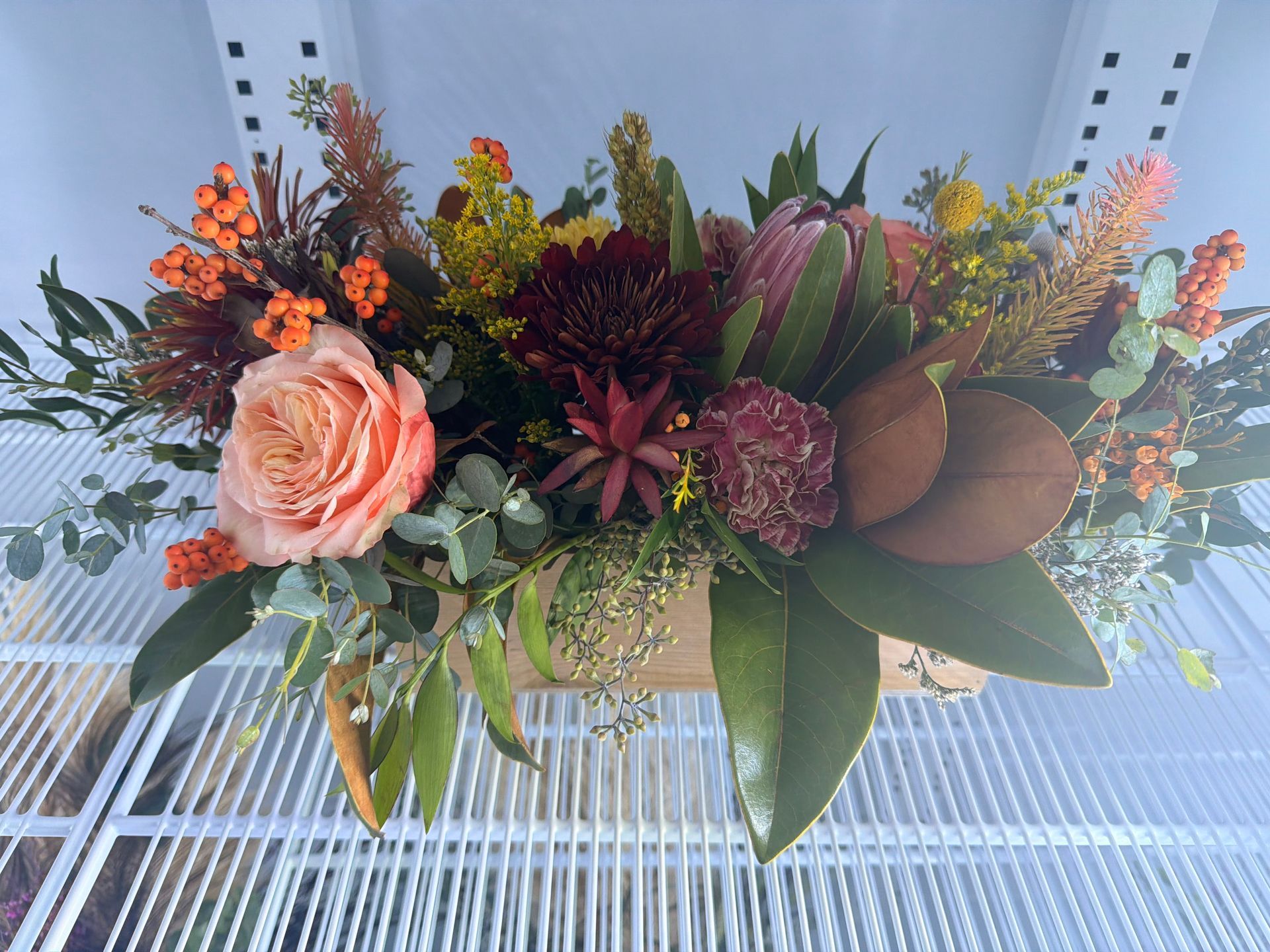Happy birthday card in a bouquet of pink and peach flowers with pink ribbon.