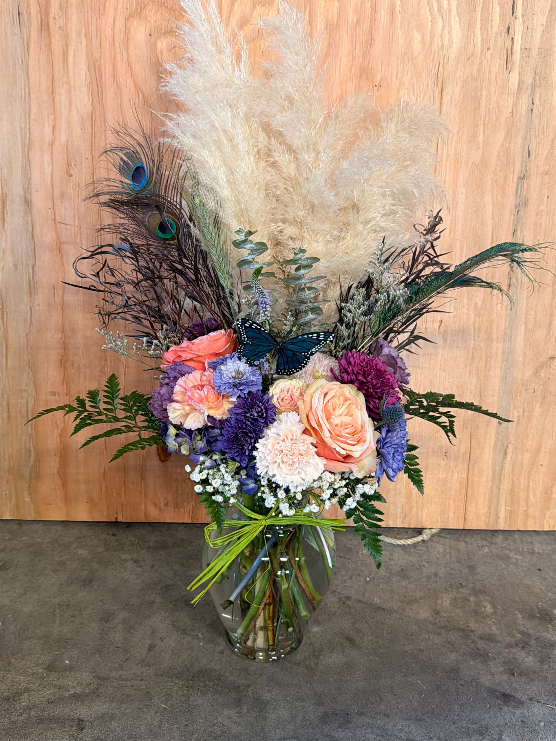 Bouquet of pink and purple flowers rests on concrete blocks in an outdoor setting.
