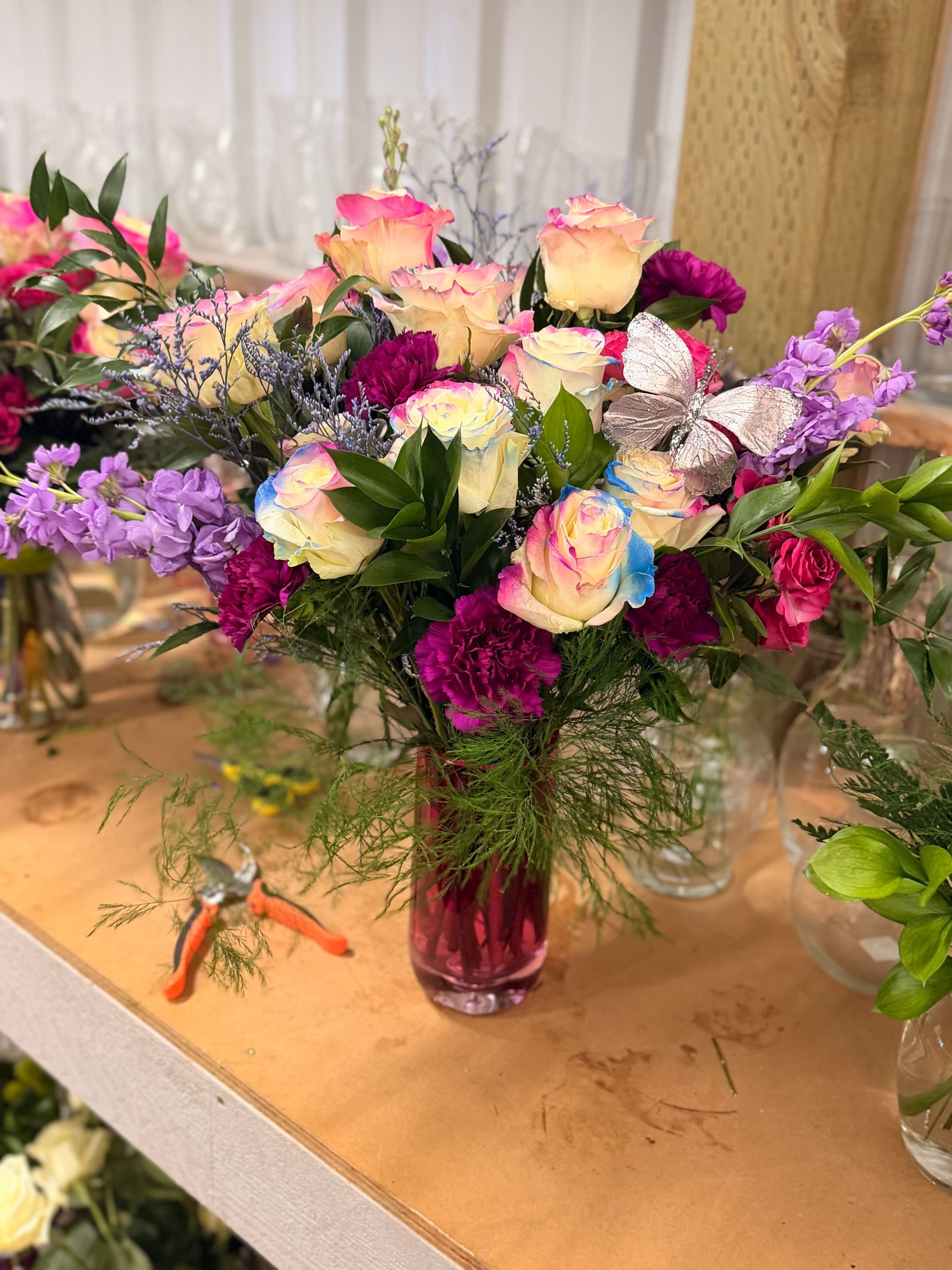 Bouquet of pink and yellow roses, and small white flowers on a table.