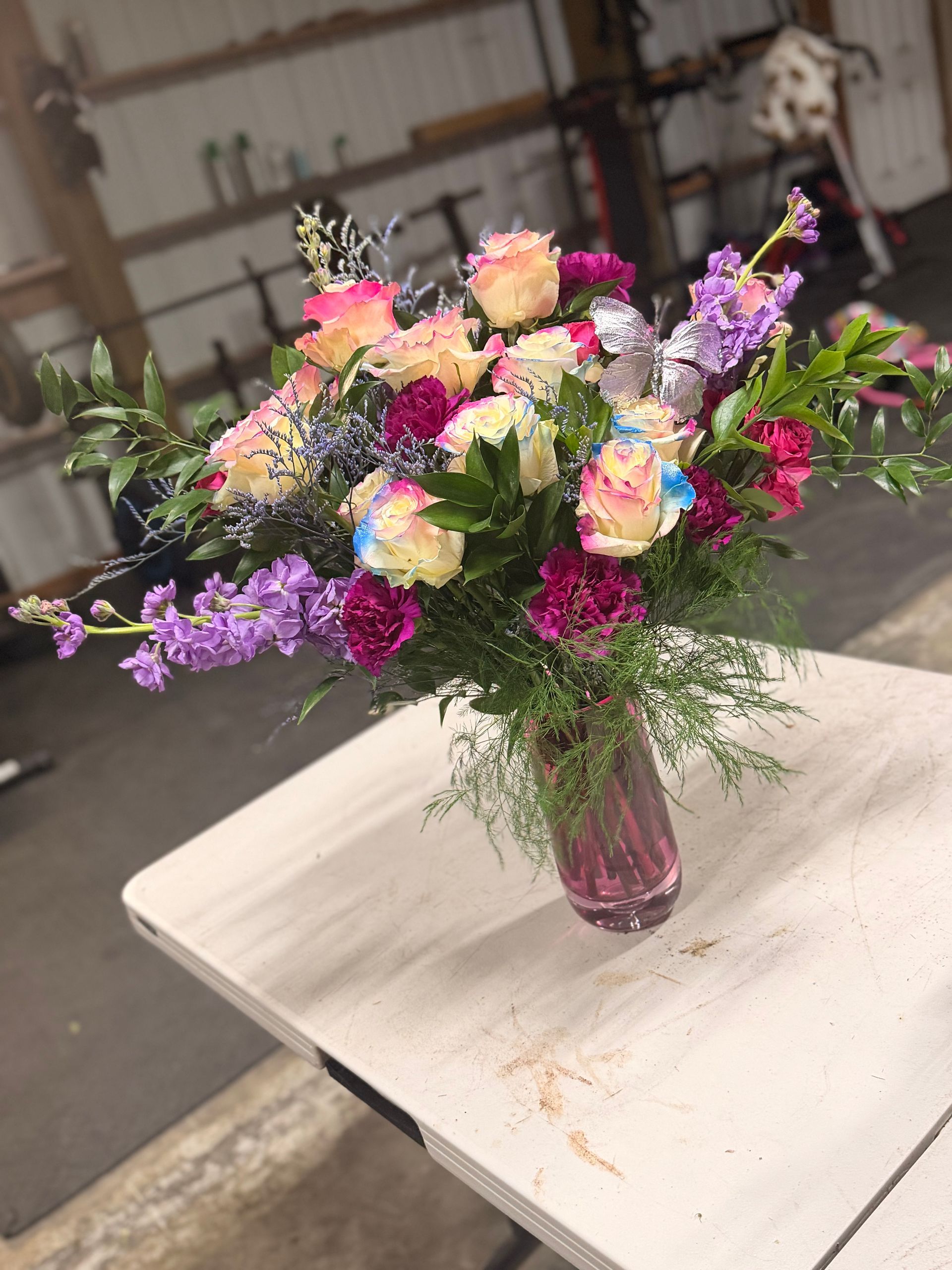 A vibrant floral arrangement in a vase on a wooden surface.