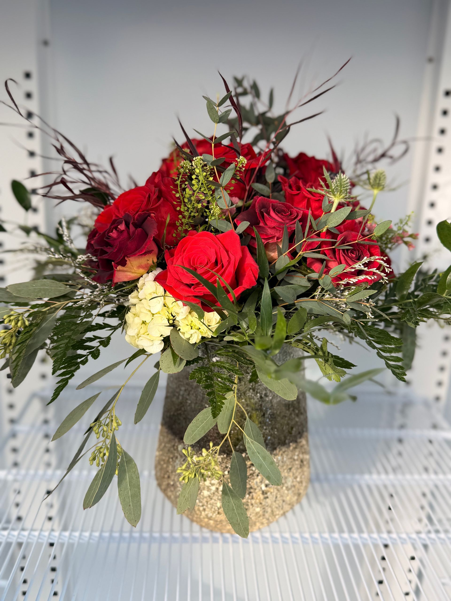 Bouquet of bright pink and other purple flowers in a glass vase.