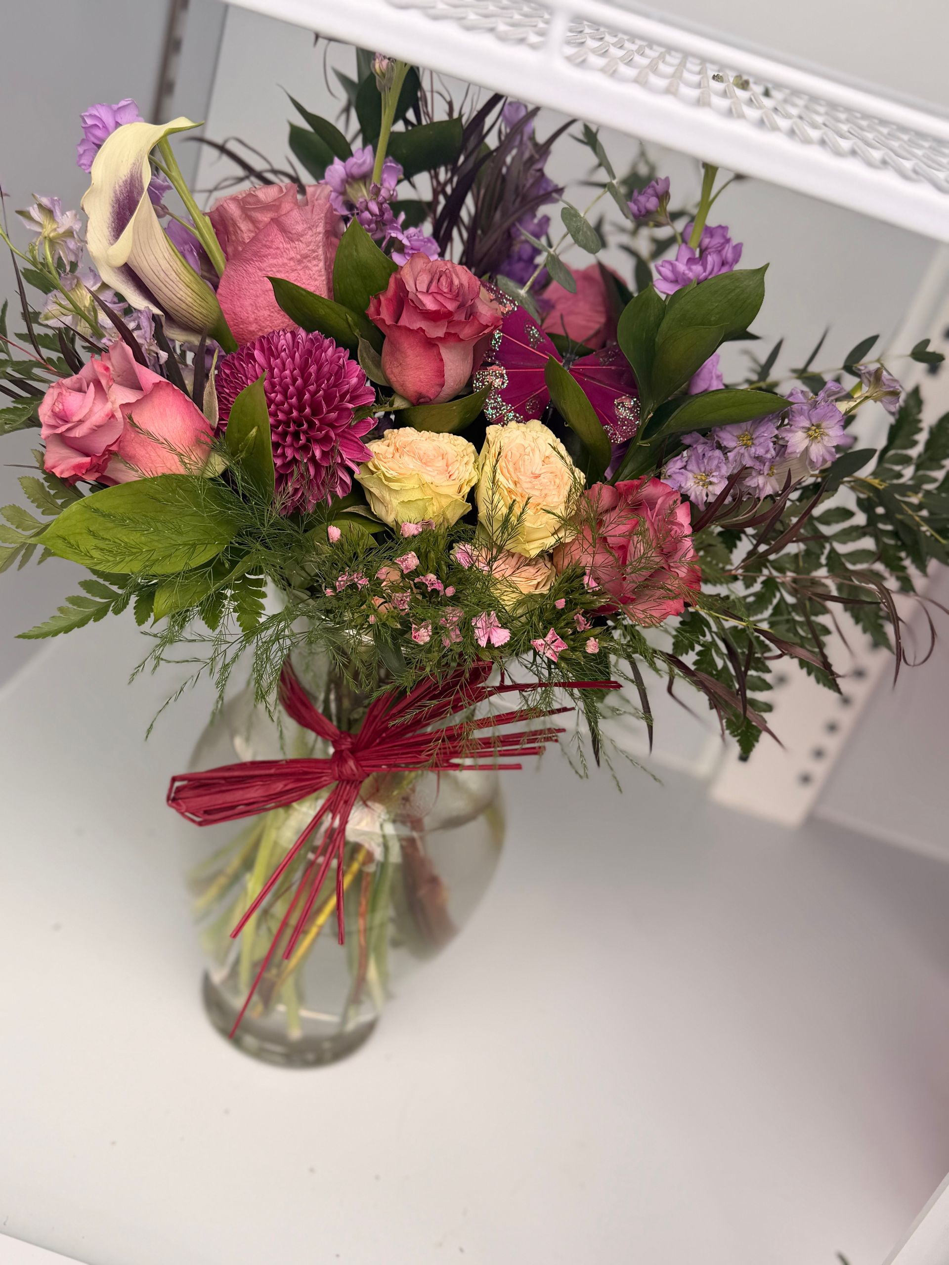 Bouquet of pink and purple flowers rests on concrete blocks in an outdoor setting.