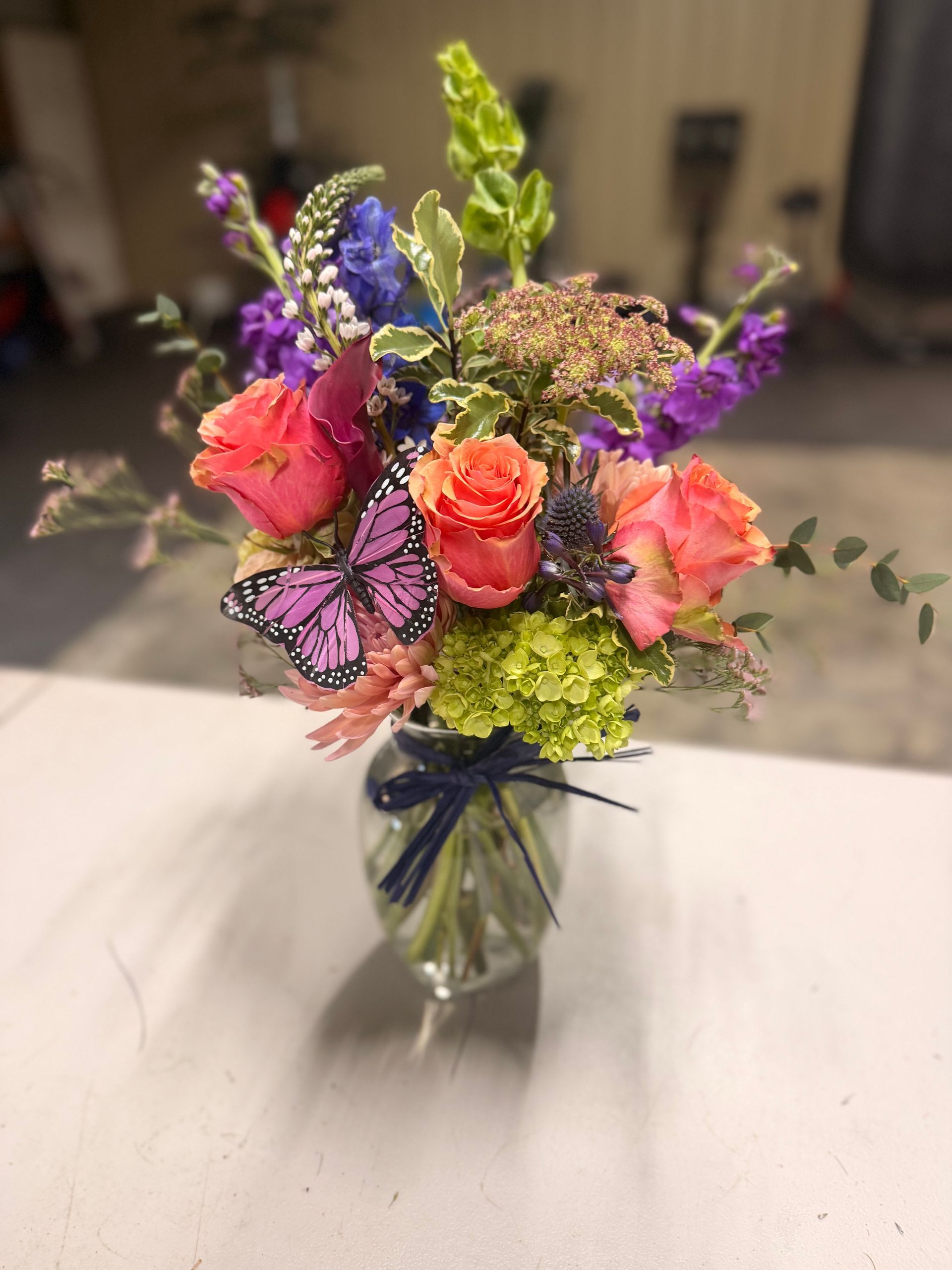 Bouquet of pink and purple flowers rests on concrete blocks in an outdoor setting.