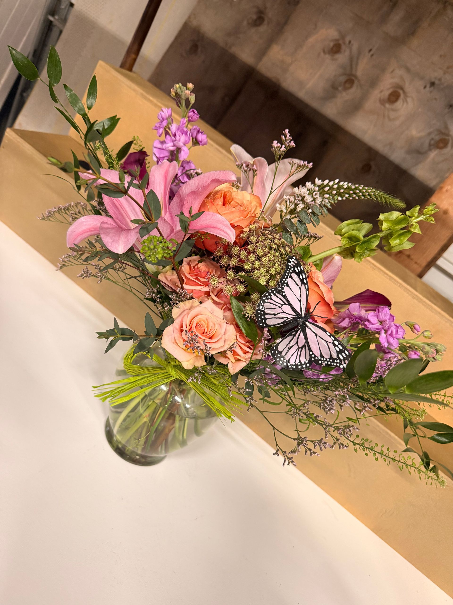 A vibrant floral arrangement in a vase on a wooden surface.