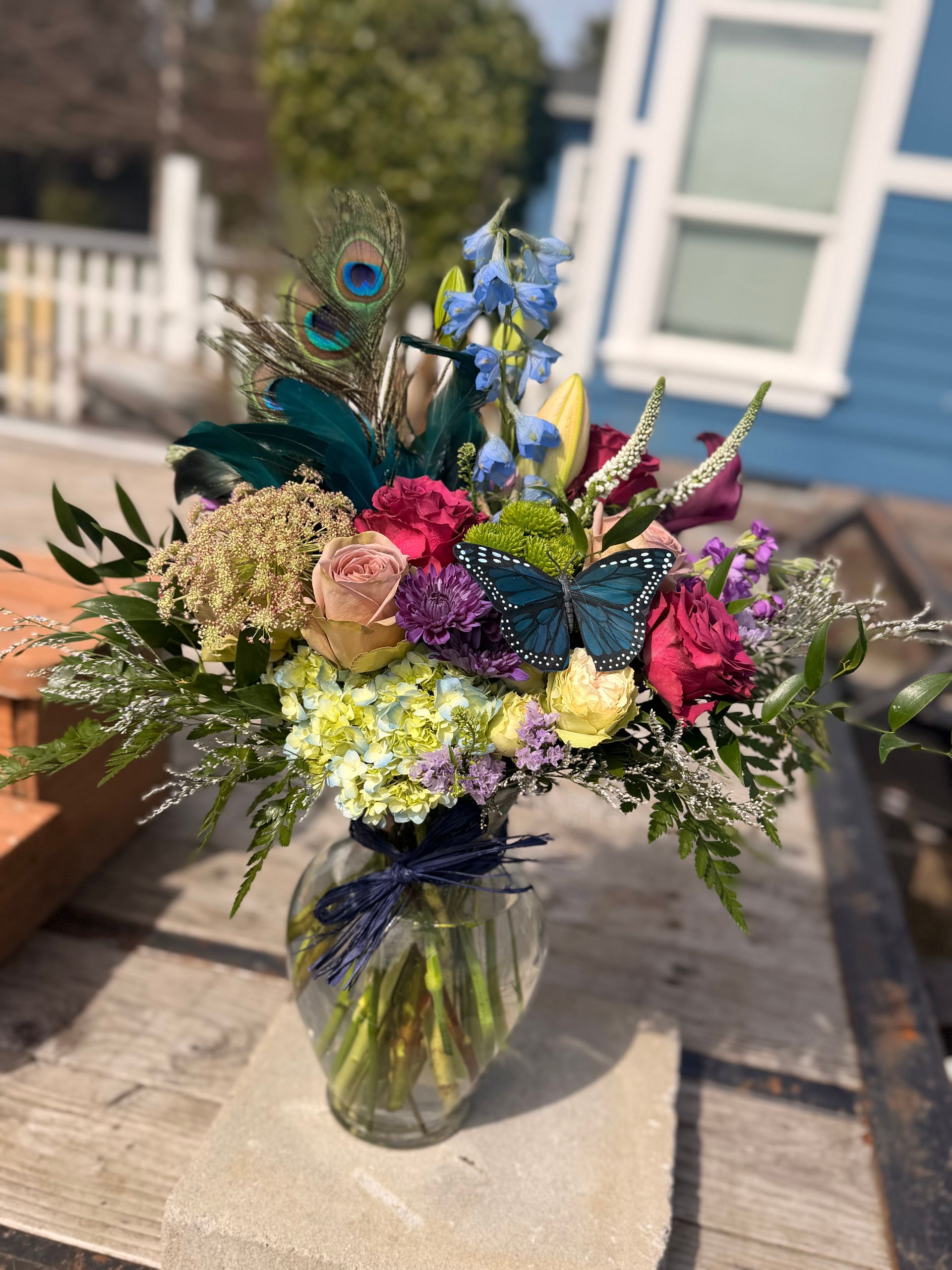 Bouquet of pink and purple flowers rests on concrete blocks in an outdoor setting.