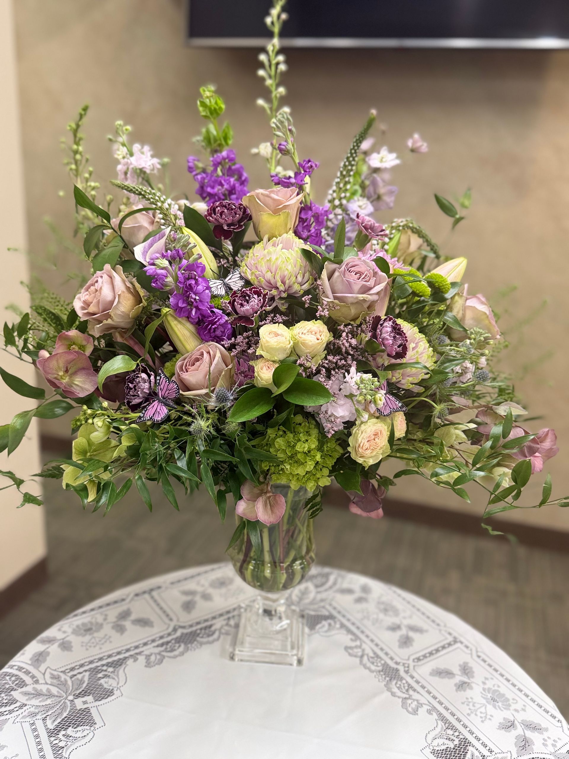 Bouquet of bright pink and other purple flowers in a glass vase.