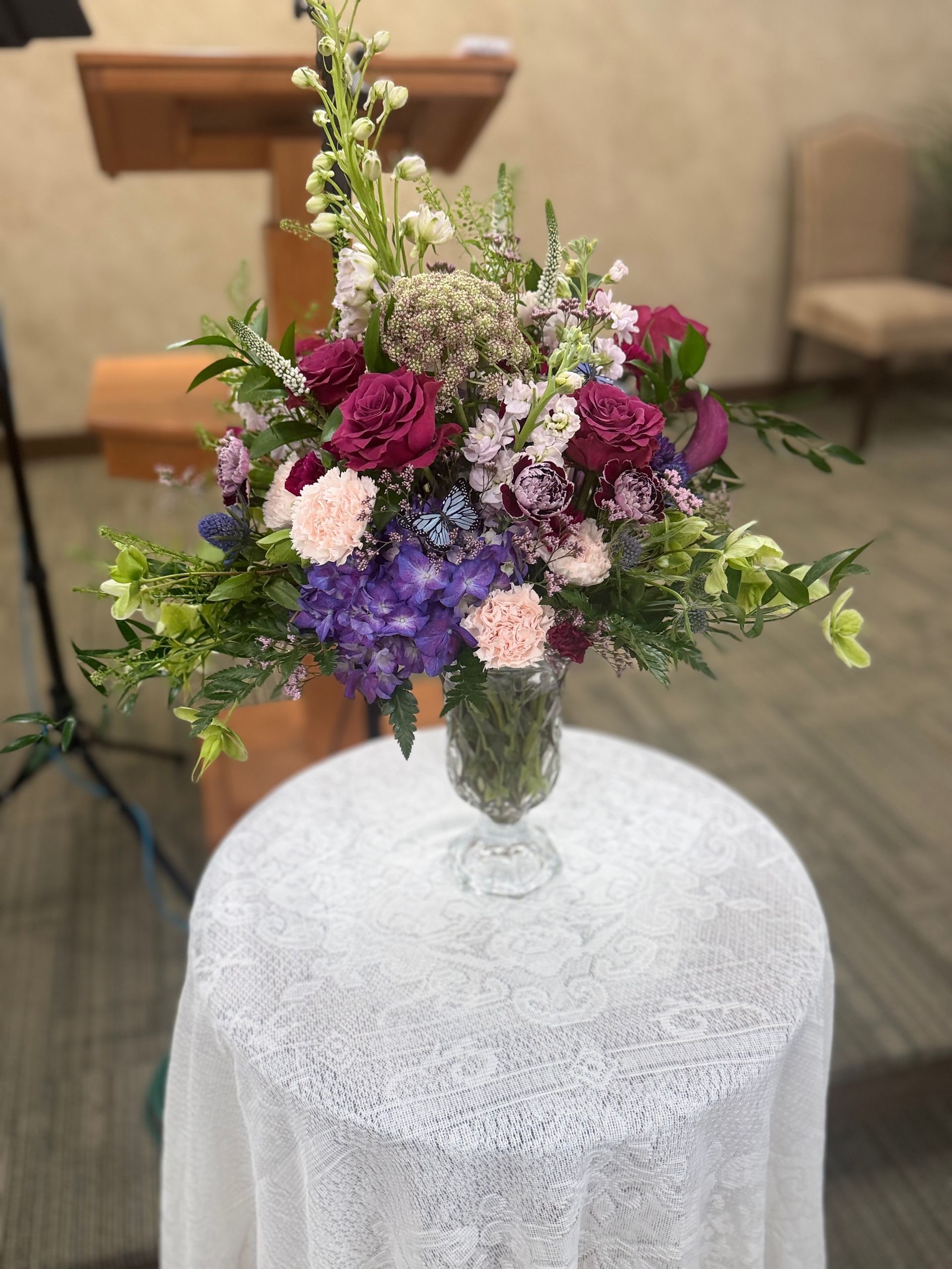 A vibrant floral arrangement in a vase on a wooden surface.