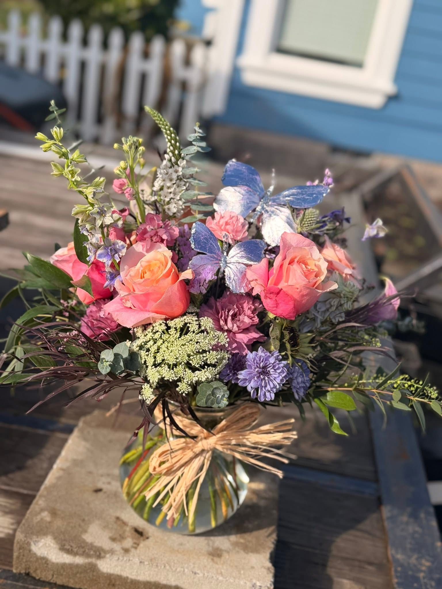 A vibrant floral arrangement in a vase on a wooden surface.