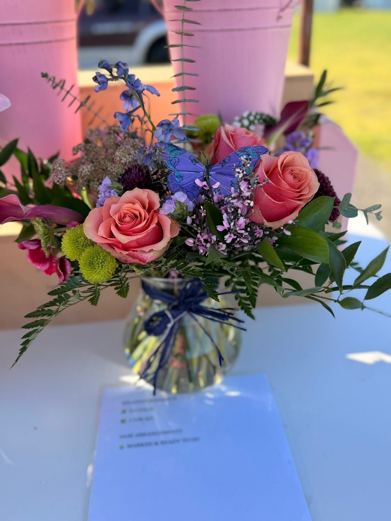 Bouquet of bright pink and other purple flowers in a glass vase.
