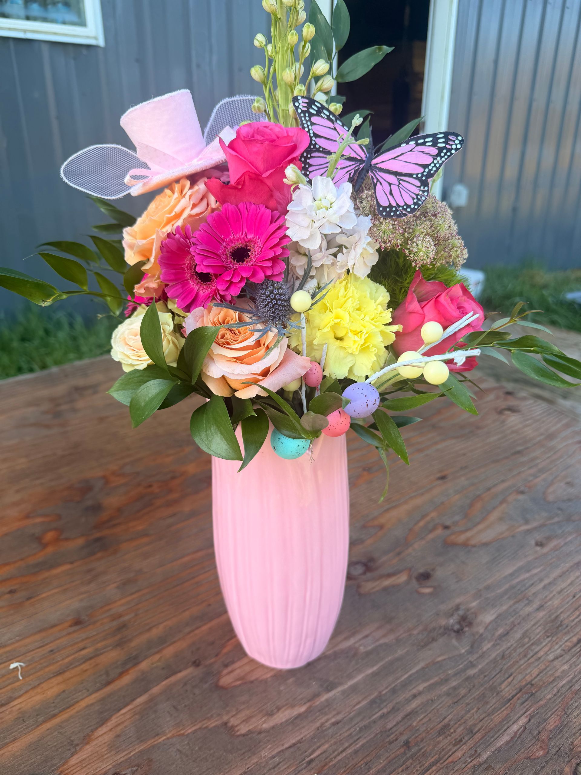 Bouquet of bright pink and other purple flowers in a glass vase.