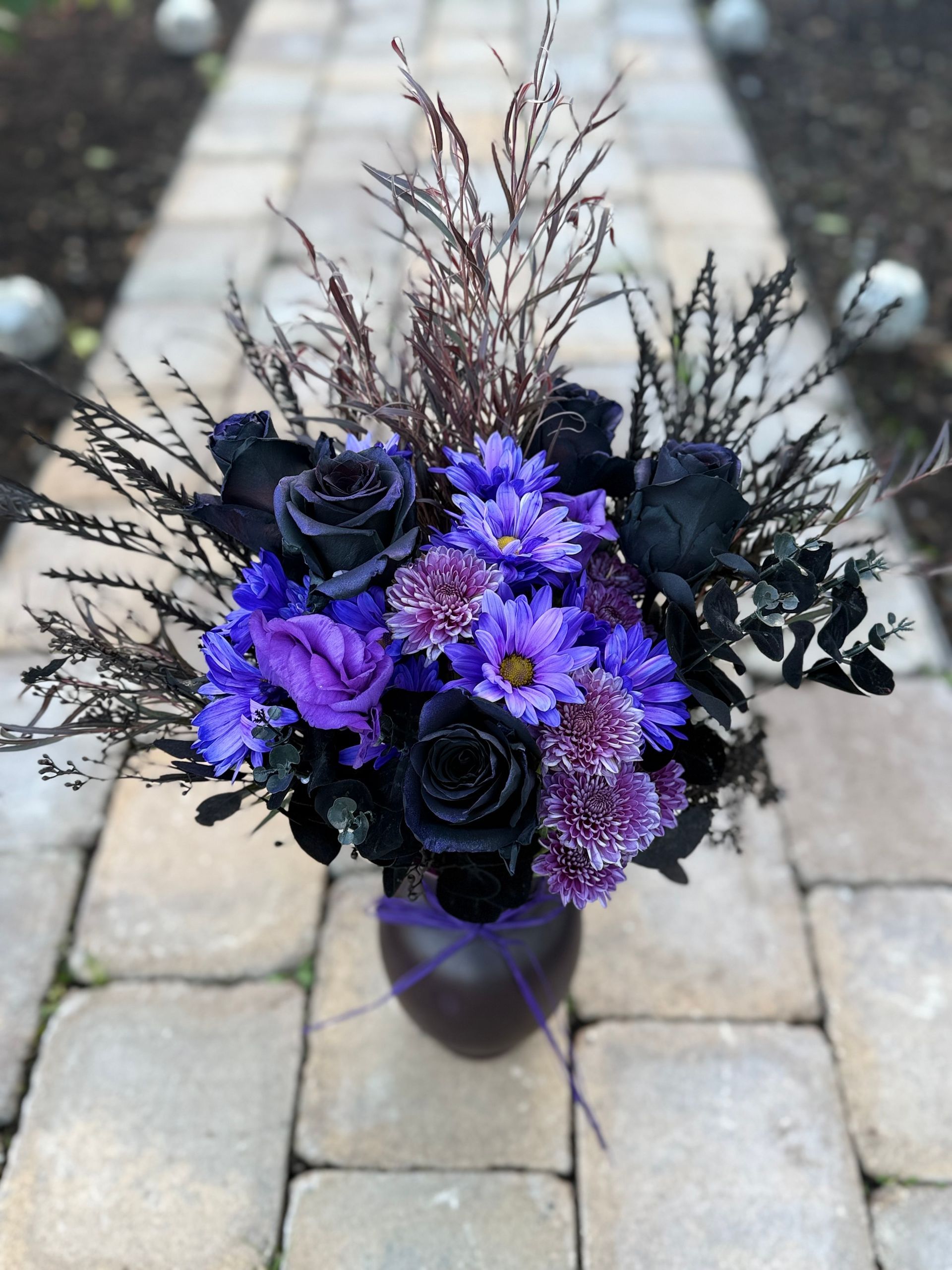 Happy birthday card in a bouquet of pink and peach flowers with pink ribbon.