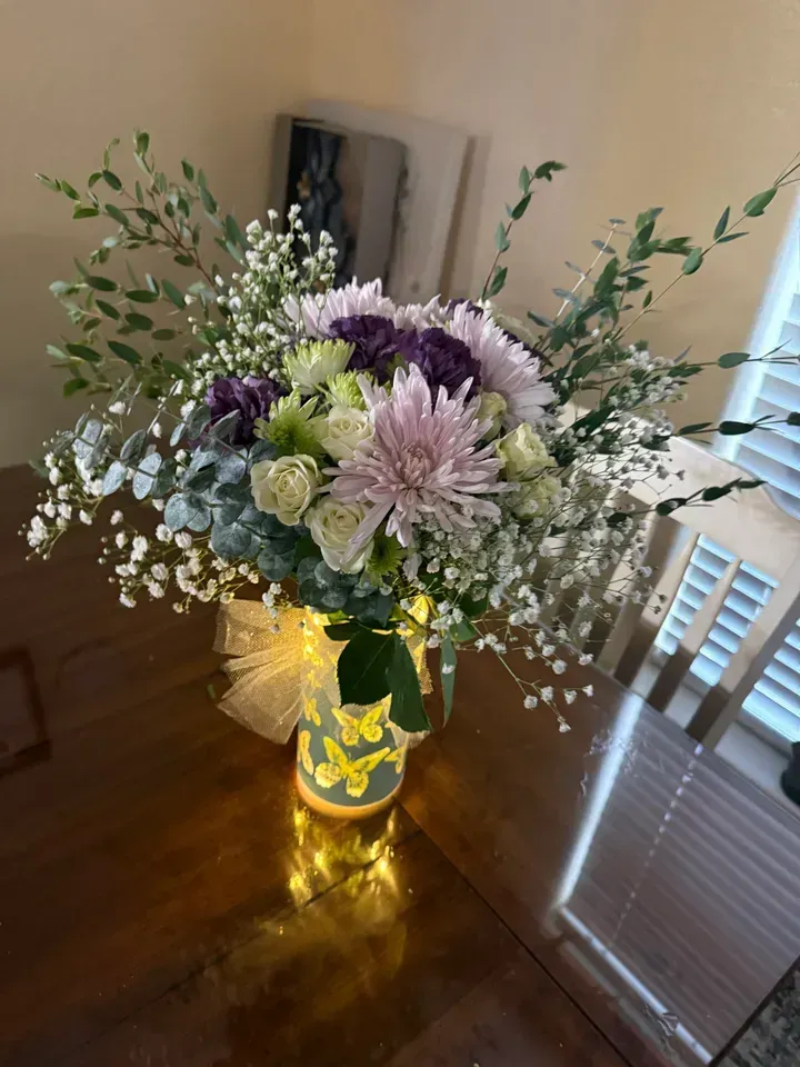 Bouquet of bright pink and other purple flowers in a glass vase.