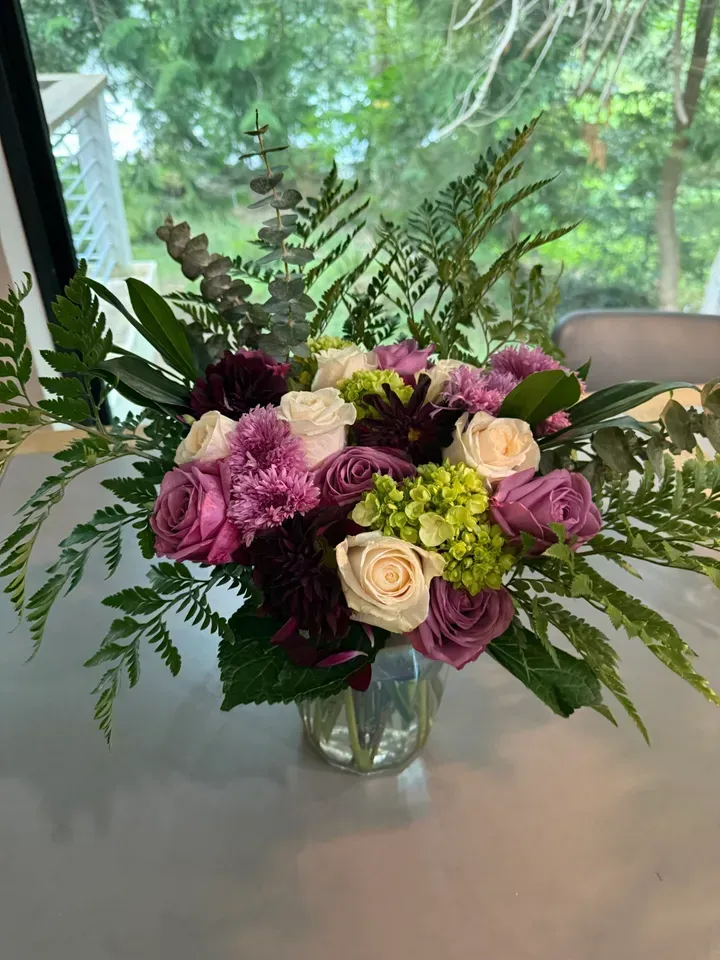 Floral arrangement in clear vase on a table.