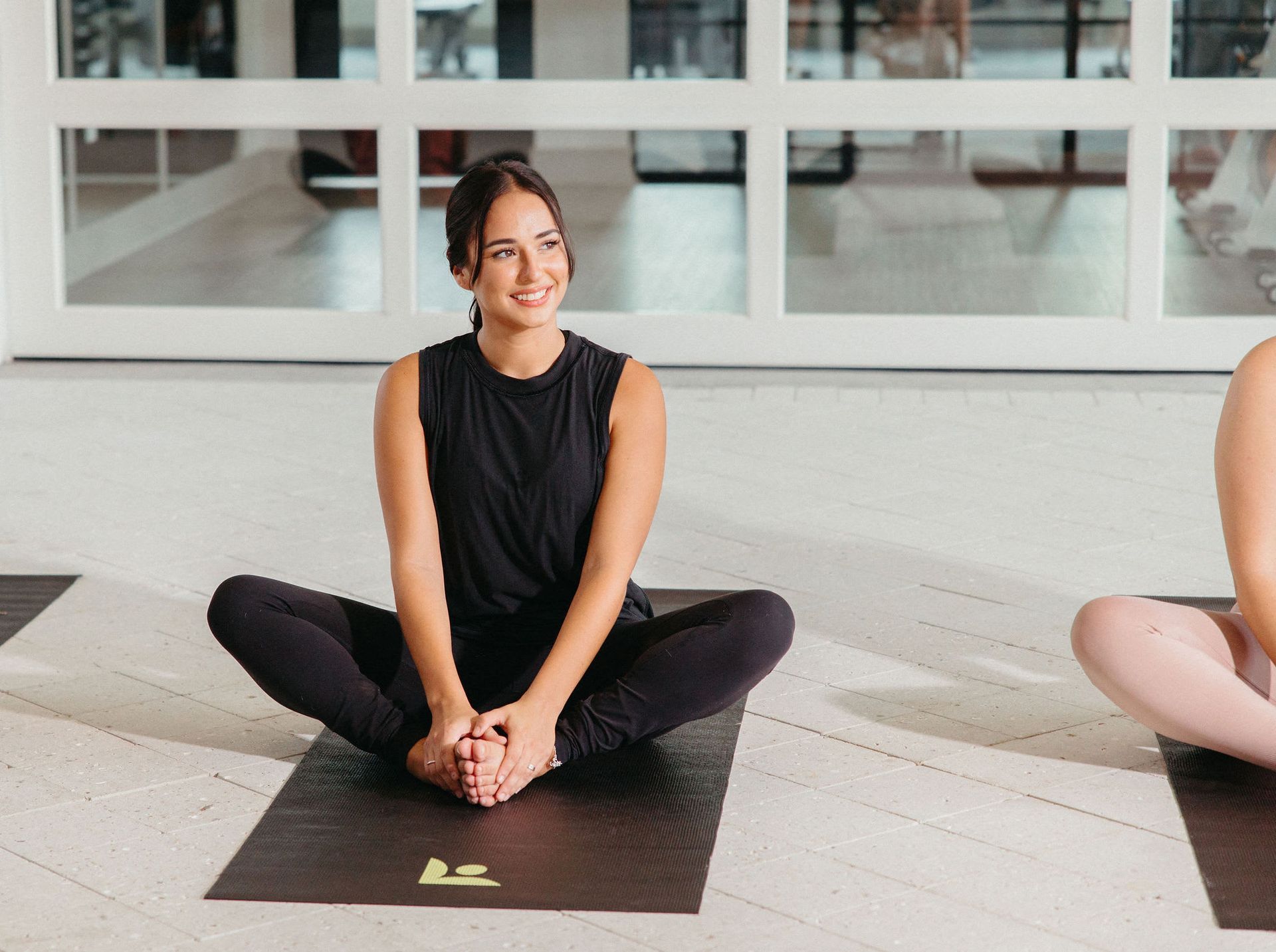 A woman is sitting on a yoga mat at Livano Wildwood