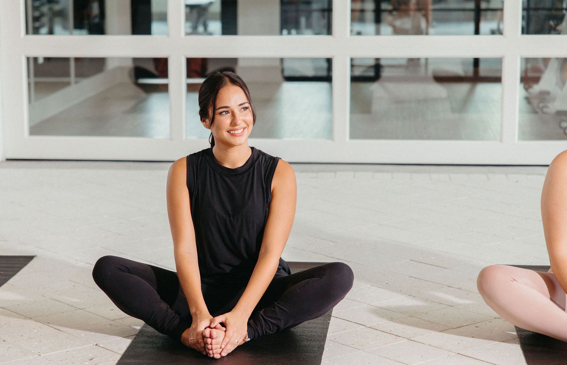 A woman is sitting on a yoga mat at Livano Wildwood