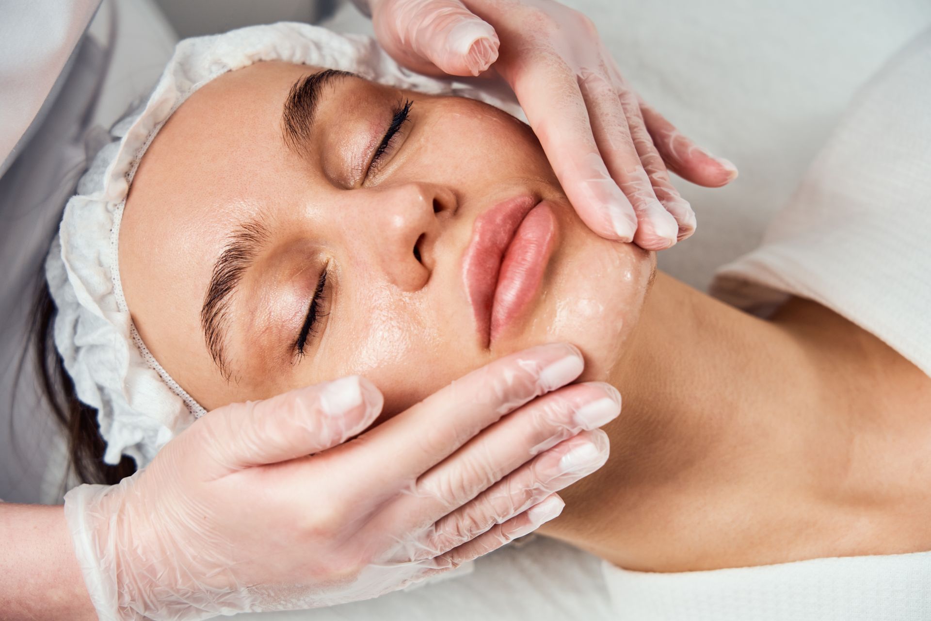 A woman is getting a facial treatment at a beauty salon.