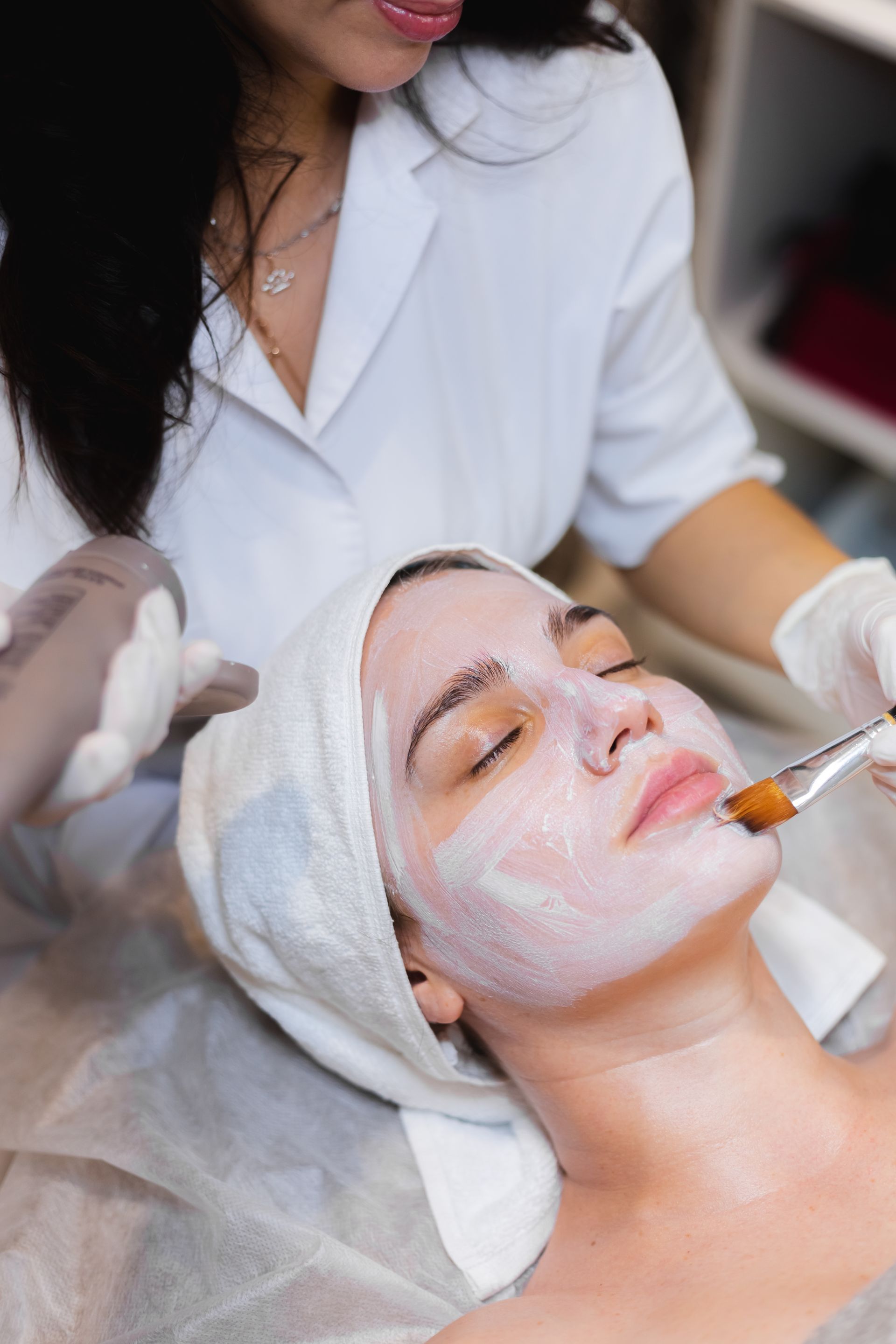 A woman is getting a facial treatment at a beauty salon.