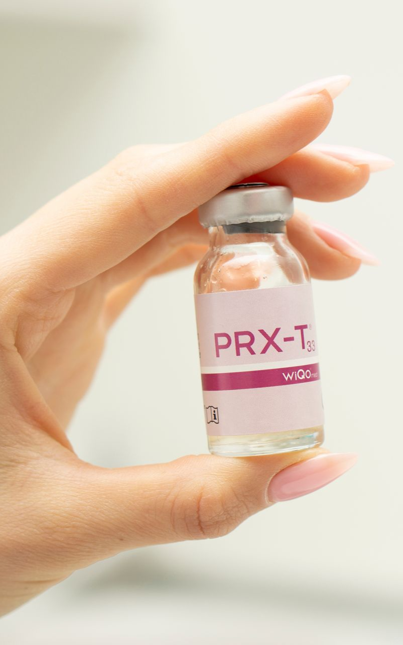 Hand holding a small vial labeled