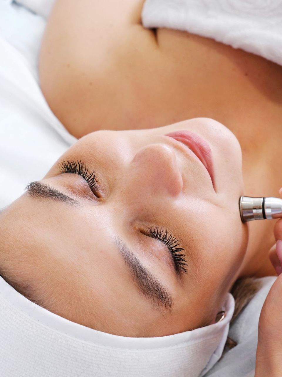 A woman is getting a treatment on her face