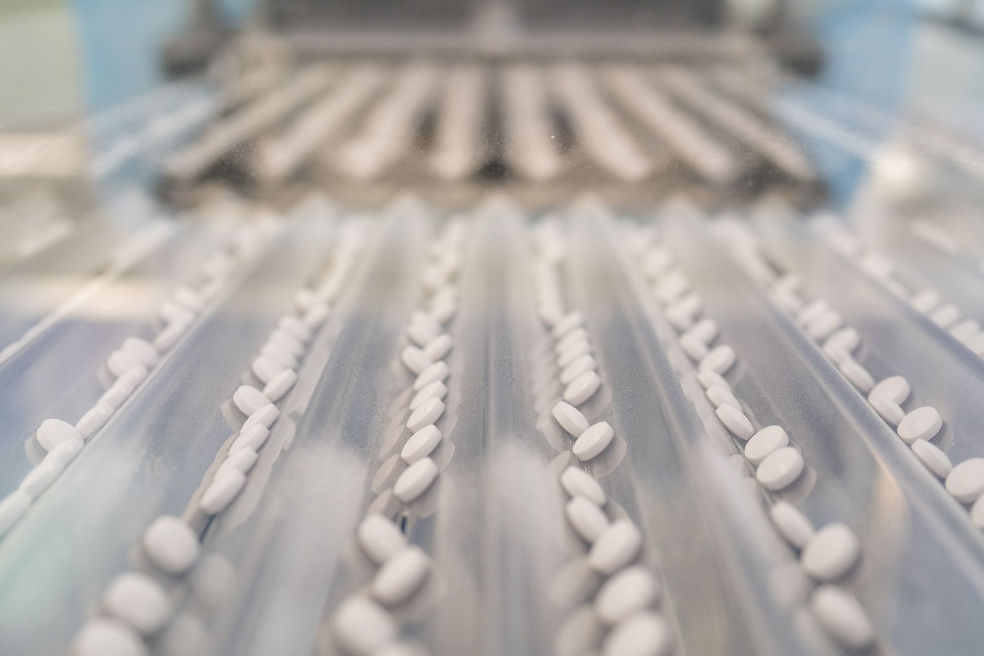 Two clear tubes filled with green capsules, with a silver top, against an orange background.