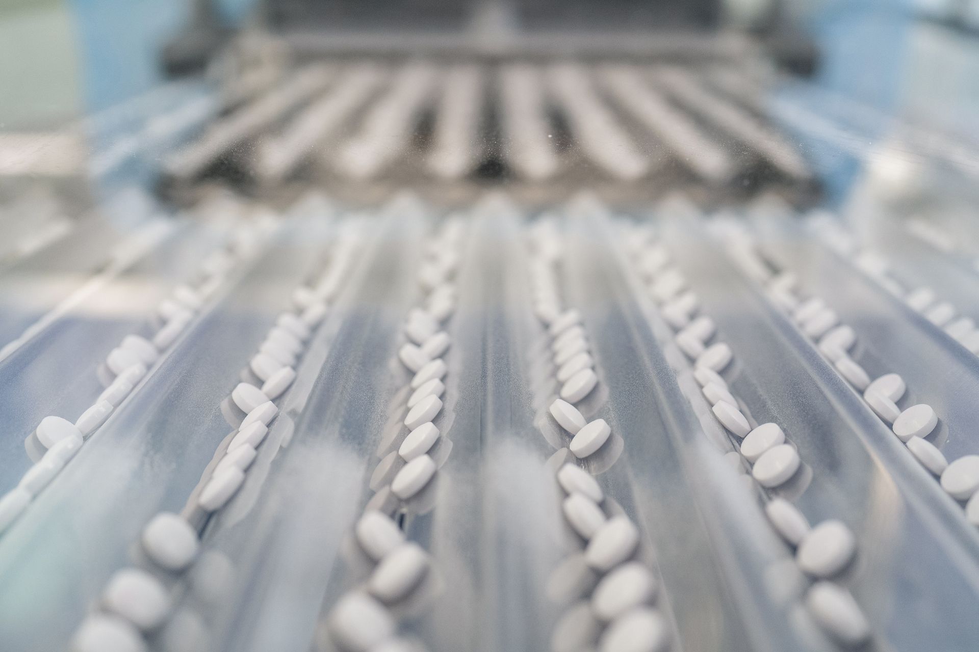 Tablets on a production line, moving along parallel tracks.