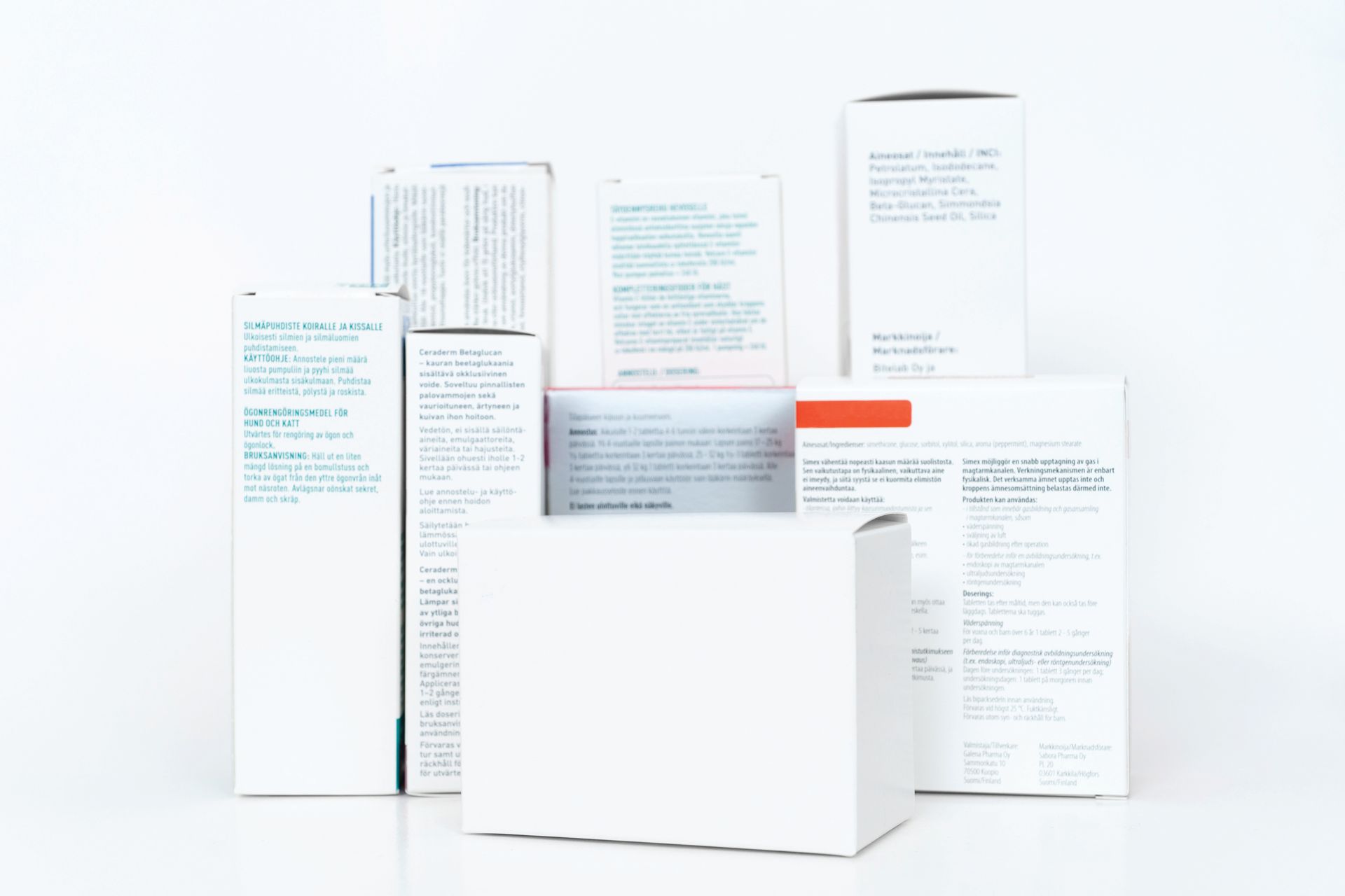 White medication boxes stacked on a white surface. Text on some boxes is visible.