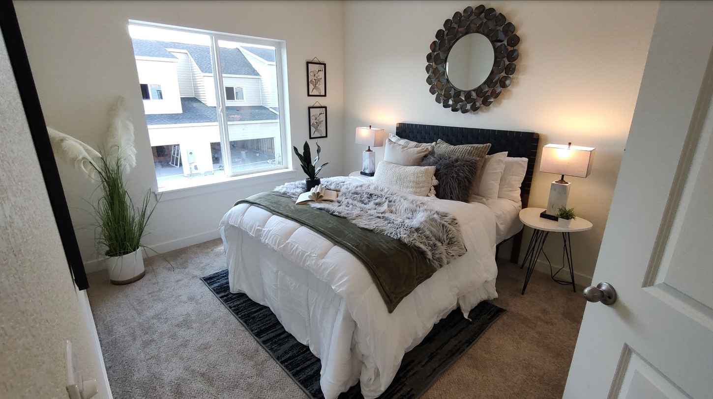A bedroom with a large bed and a mirror on the wall.