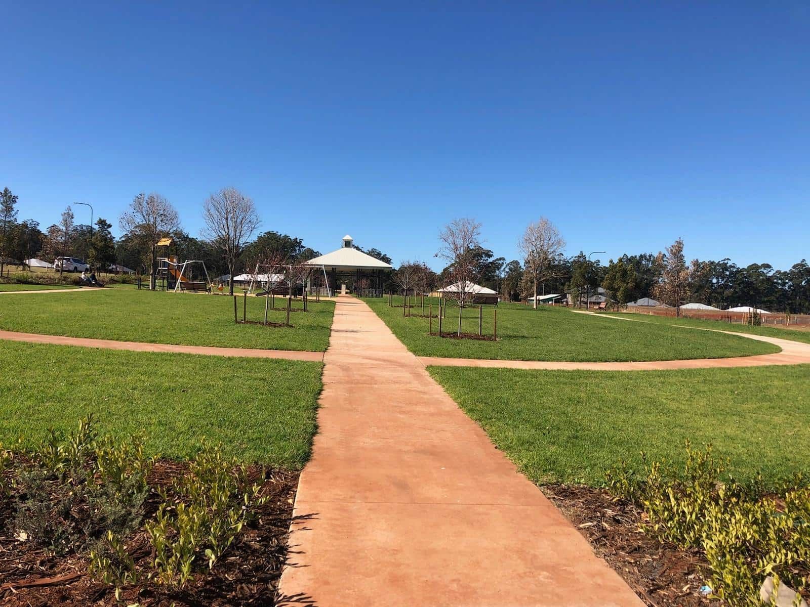 Pathway leading to a gazebo in a grassy park under a clear blue sky. — Placid Hills Turf in Highfields, QLD