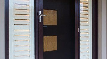 A Close Up of a Door With Shutters on It — Abode Shutters & Blinds In Old Bar, NSW