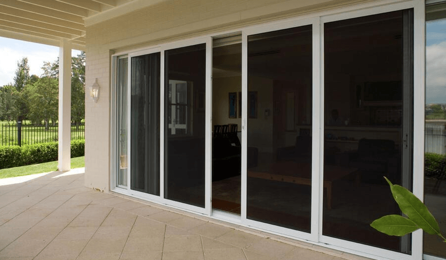 A Patio With Sliding Glass Doors Leading to a Living Room — Abode Shutters & Blinds In Harrington, NSW