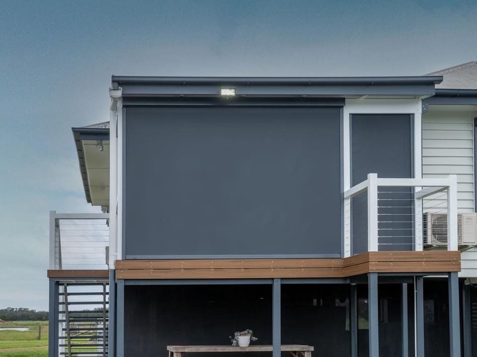 A House With a Large Screen on the Side of It — Abode Shutters & Blinds In Taree South, NSW