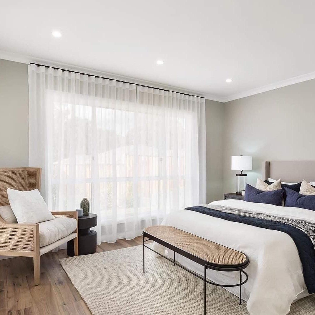 A Bedroom With a Bed , Chair , Bench and Large Window — Abode Shutters & Blinds In Taree South, NSW