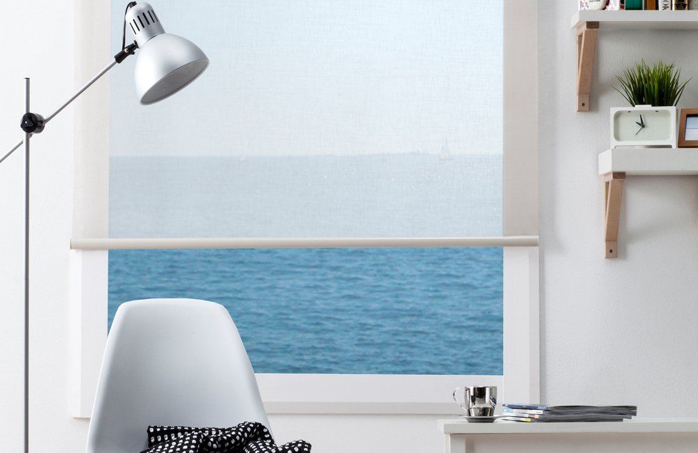 A Desk With a Lamp and a Chair in Front of a Window With a View of the Ocean — Abode Shutters & Blinds In Taree South, NSW