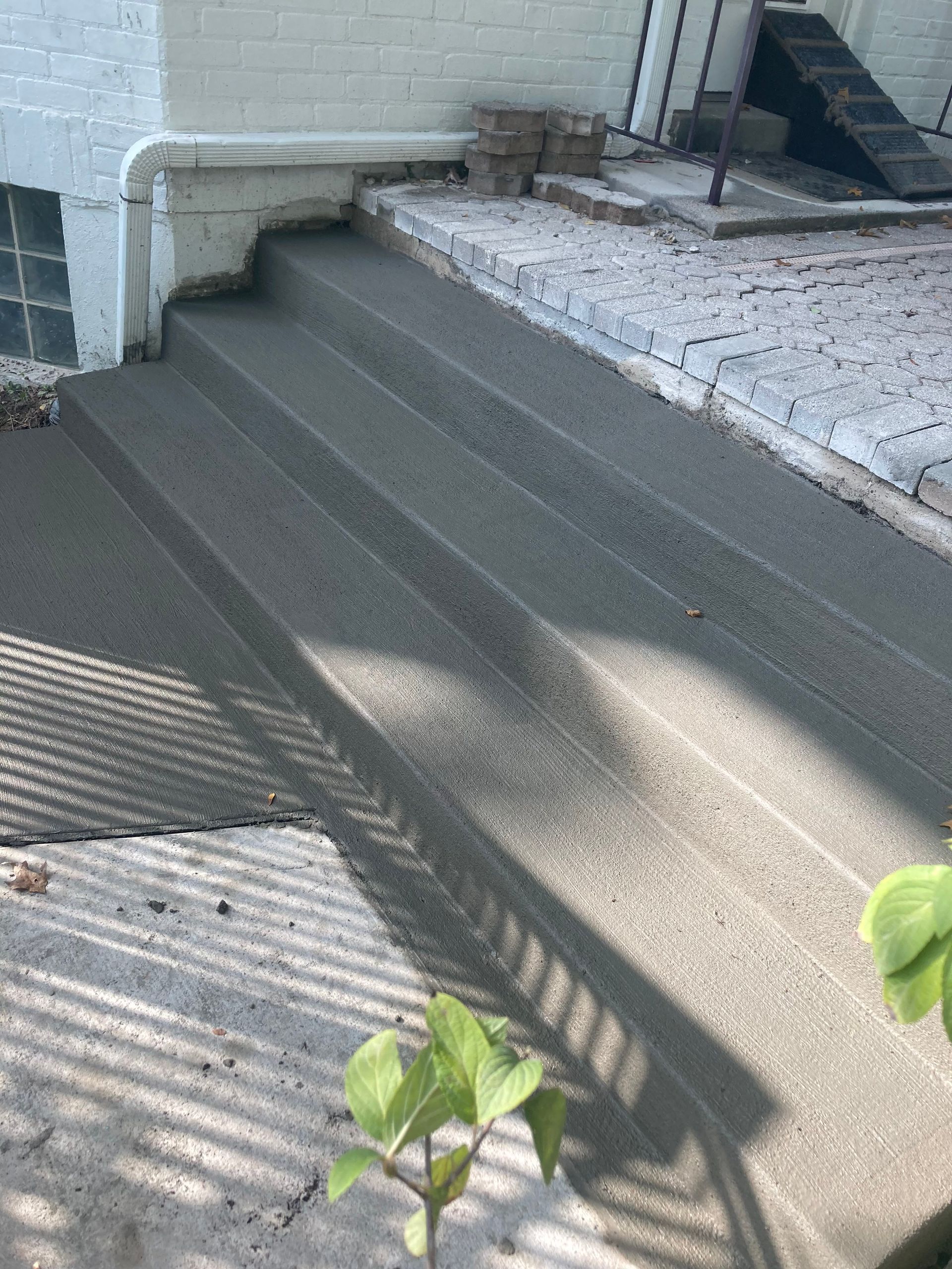 A set of concrete stairs leading up to a house.