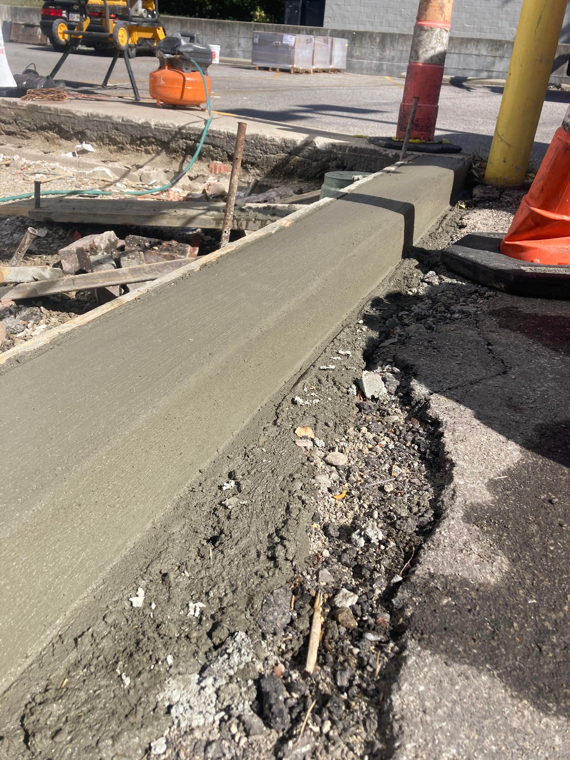 A sidewalk is being built on the side of the road.