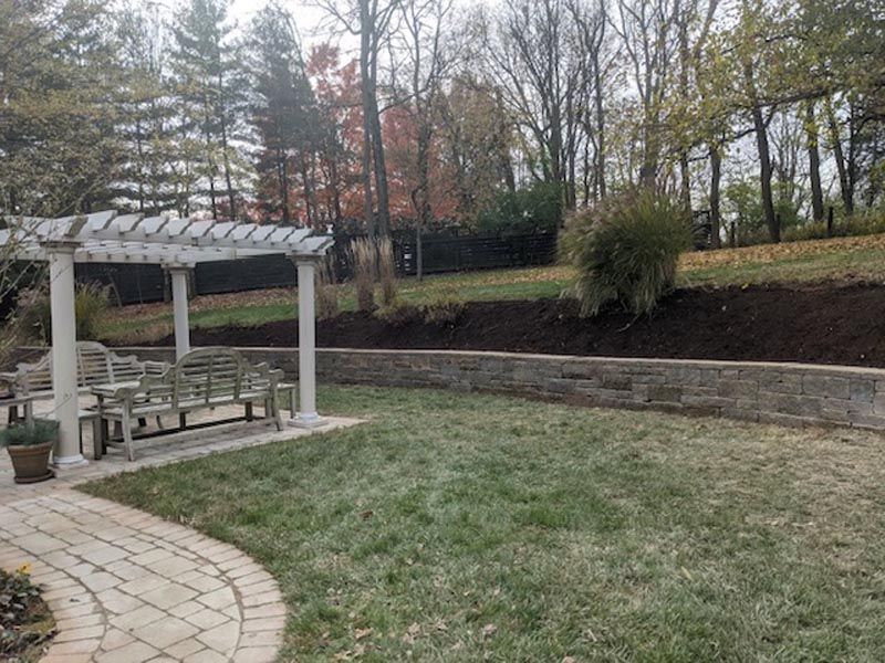 There is a pergola in the middle of the backyard.