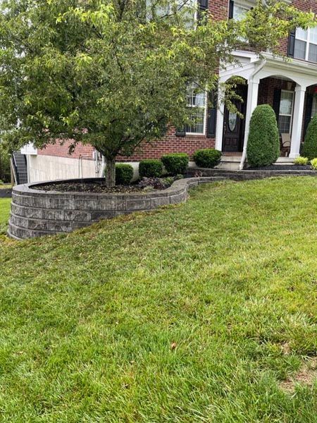 A large lush green lawn in front of a brick house.