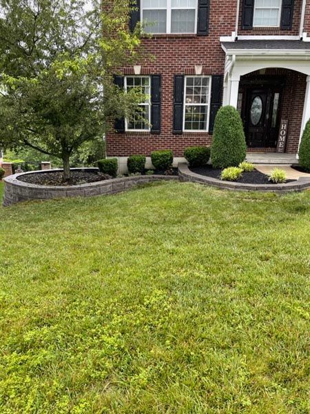 A large brick house with a lush green lawn in front of it.