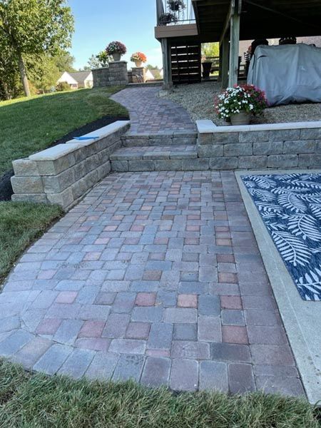 A brick walkway leading to a deck and stairs.