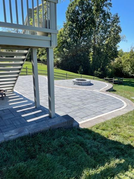 A patio with a fire pit and stairs leading up to it