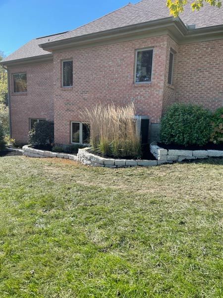 A large brick house with a lush green lawn in front of it.