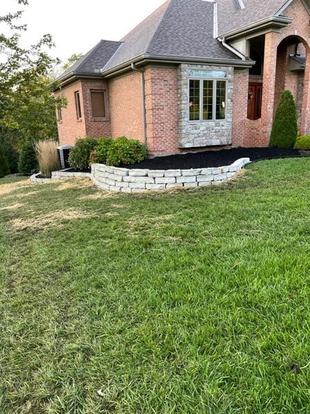 A large brick house with a large lawn in front of it.