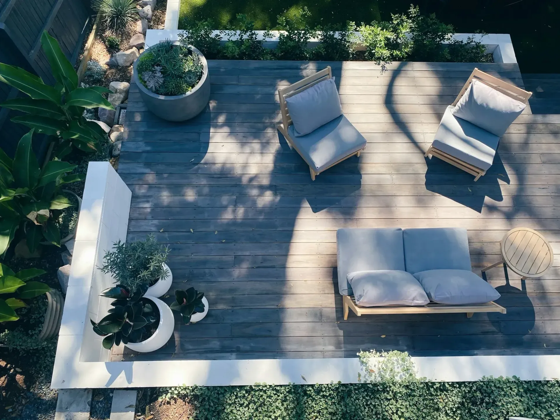 An aerial view of a wooden deck with a couch and chairs.