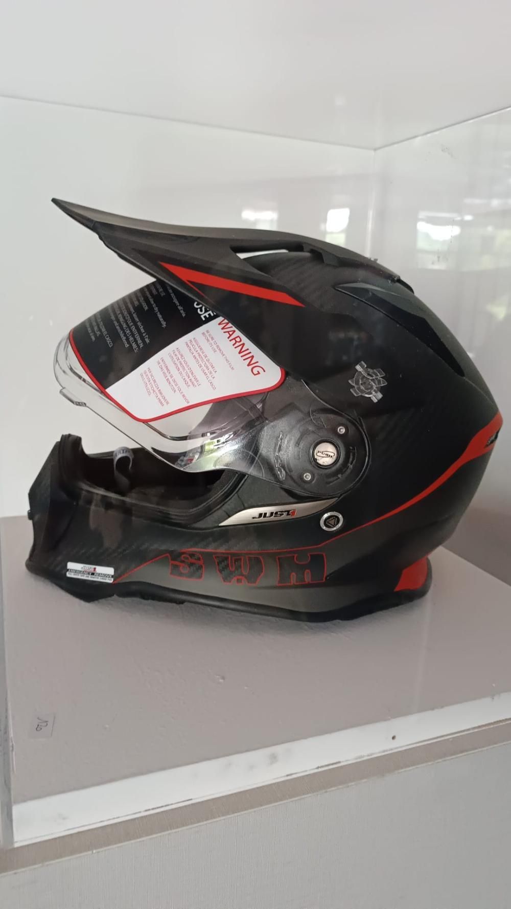Un casco da motociclista è appoggiato su un tavolo bianco.