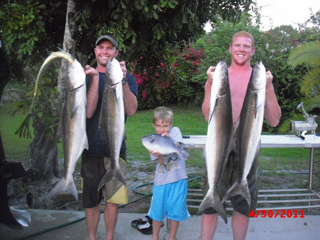 Two men and a boy holding fish in a photo taken in 2011