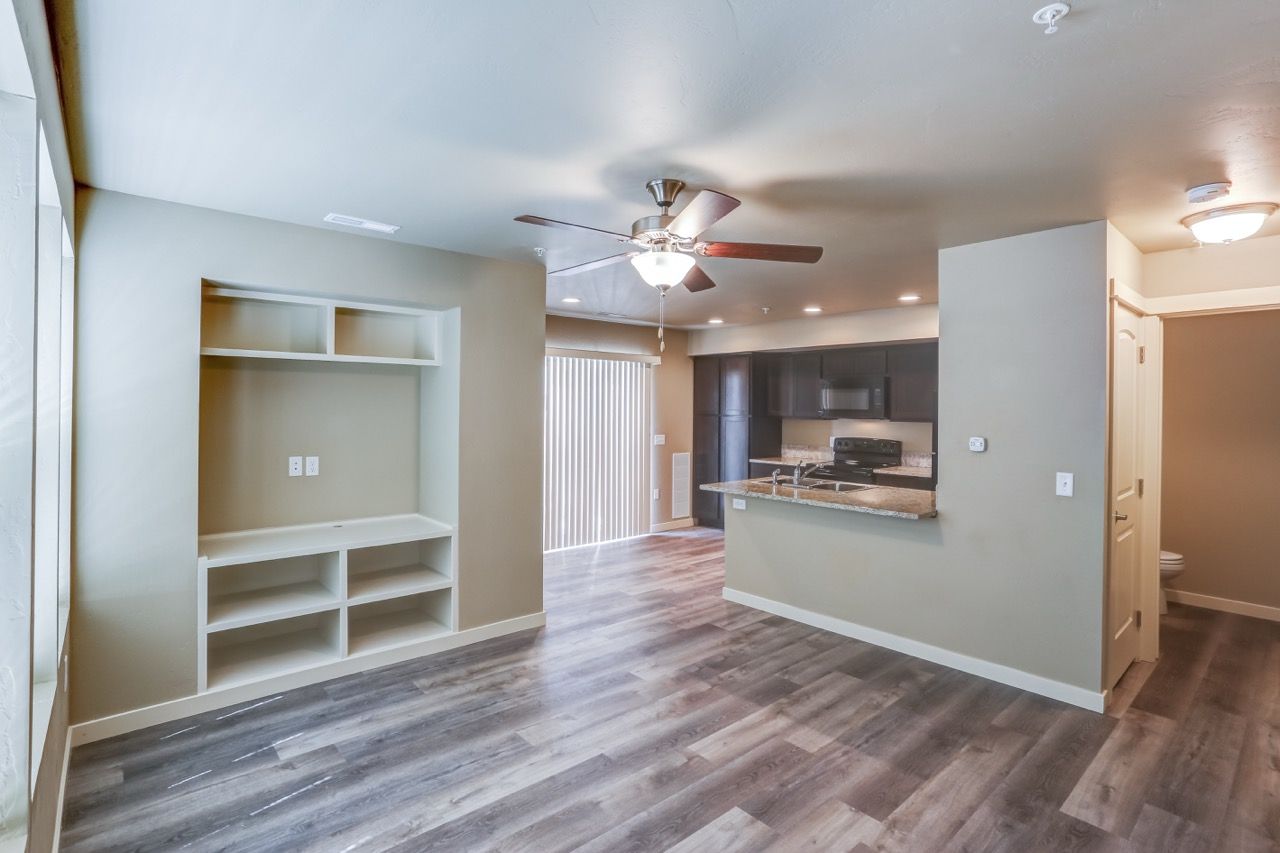 Open living area with built-in shelving, laminate flooring, and a kitchen island.