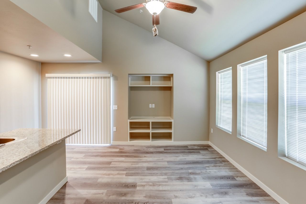 Open-concept living area with a kitchen island, built-in shelves, and large windows.