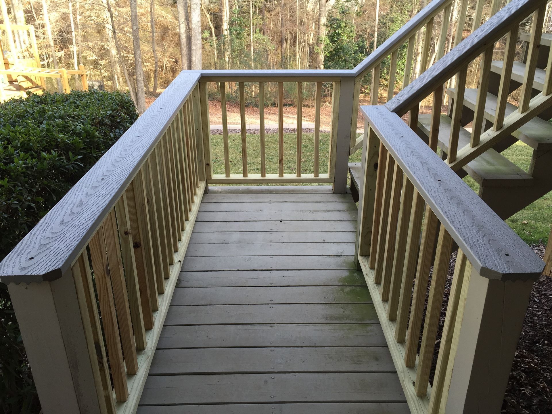 Wooden front porch with railings and steps leading down to a yard in autumn
