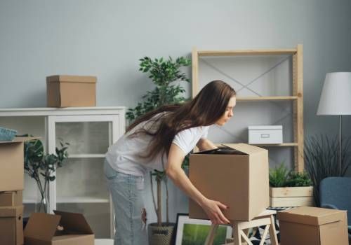 A bunch of cardboard boxes are stacked on top of each other in an empty room.